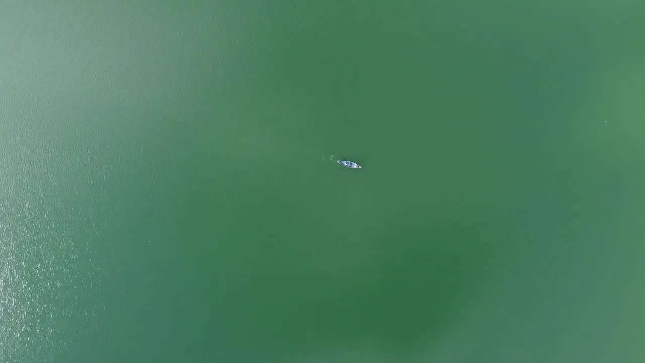 Aerial view of a fishing boat in a turquoise lake or sea