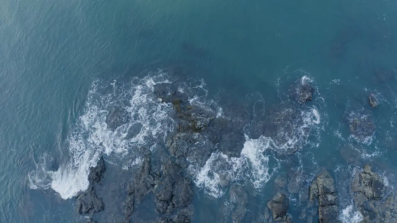 Sea waves hitting rocks aerial view