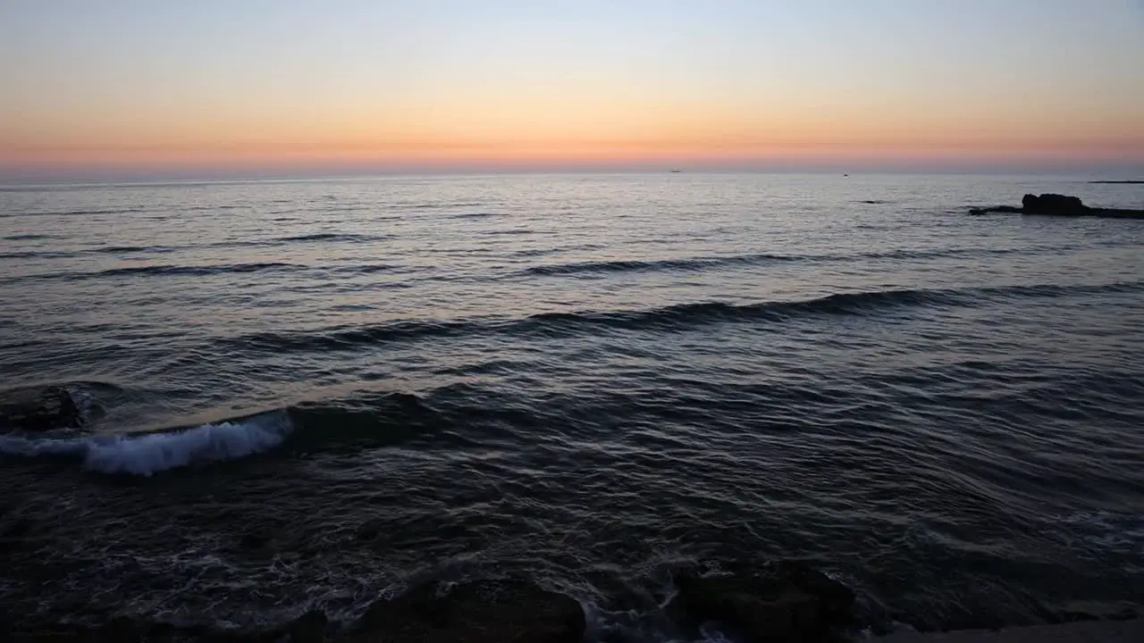 Relaxing Scene of Ocean Waves Crashing on the Shore with a Beautiful Sunset on the Horizon