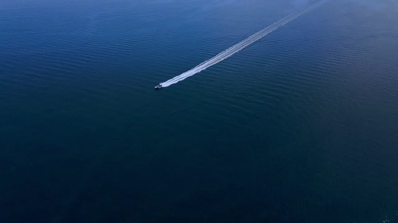 Boat speeding through the blue waters of Långedrag Gothenburg Sweden aerial