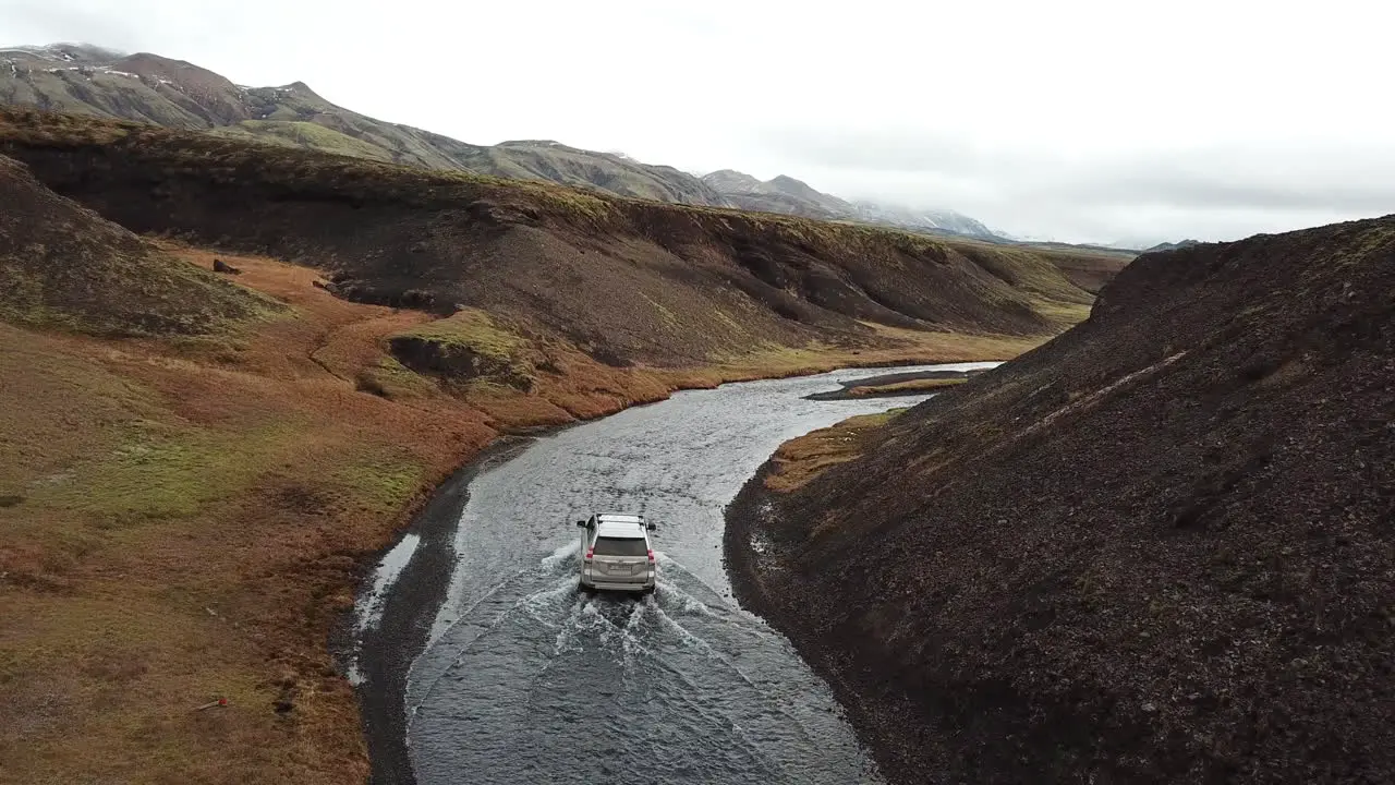 Four Wheel Vehicle in Extreme Condition Moving Over Shallow Water in Rural Iceland Tracking Aerial