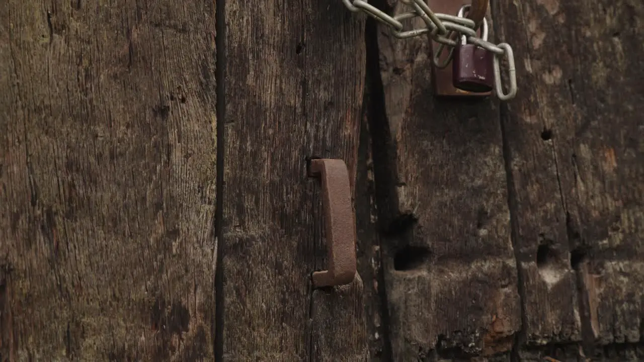 Zoom in on an old rusty metal handle on an old oak gate