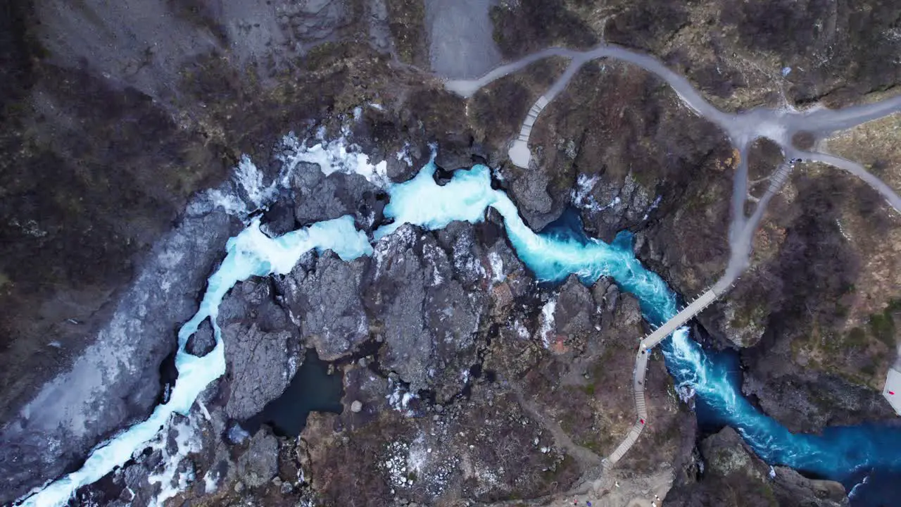 Stunning wild blue river and waterfall Barnafoss in volcanic landscape aerial top down panorama