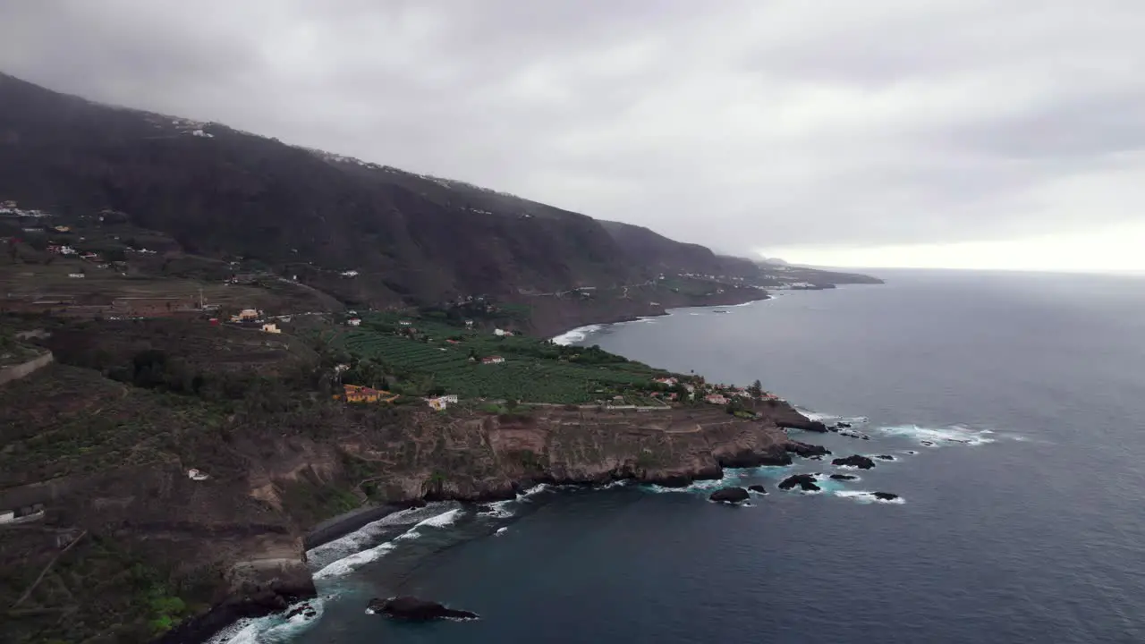 Banana plantation on rocky coastline Tenerife aerial tilt up reveal