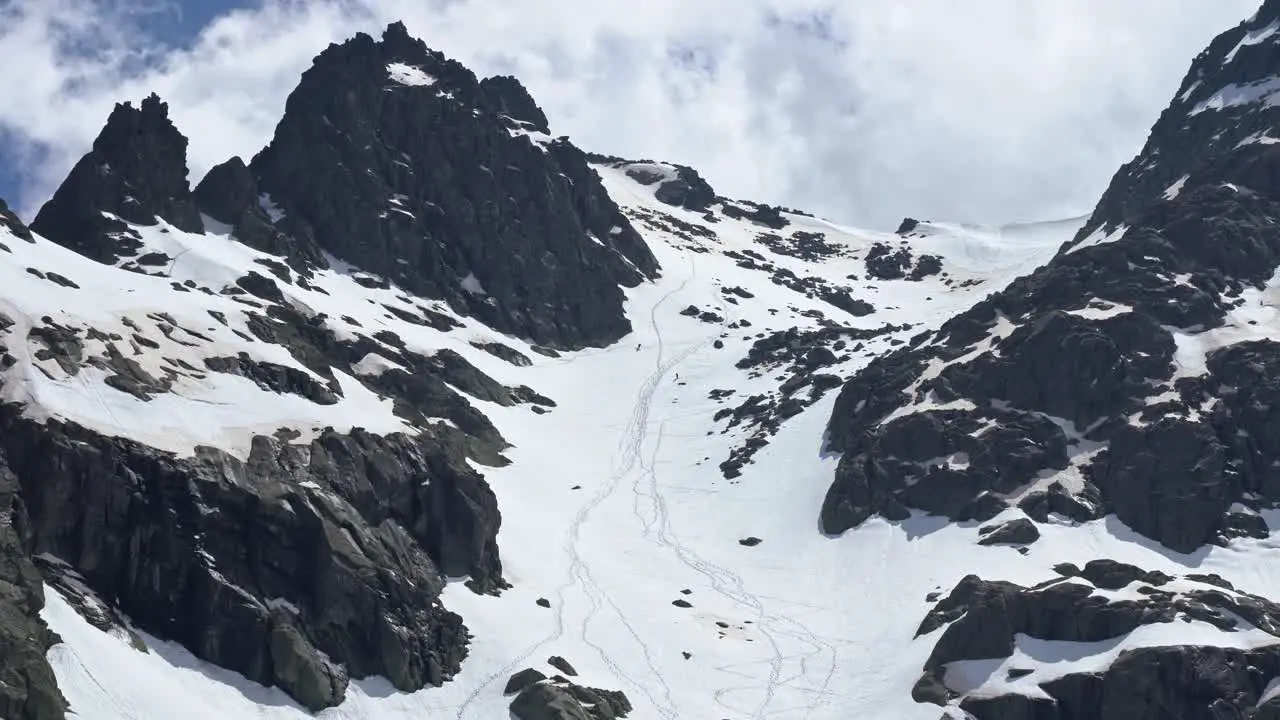 People freeriding down rocky slope of snowy mountain