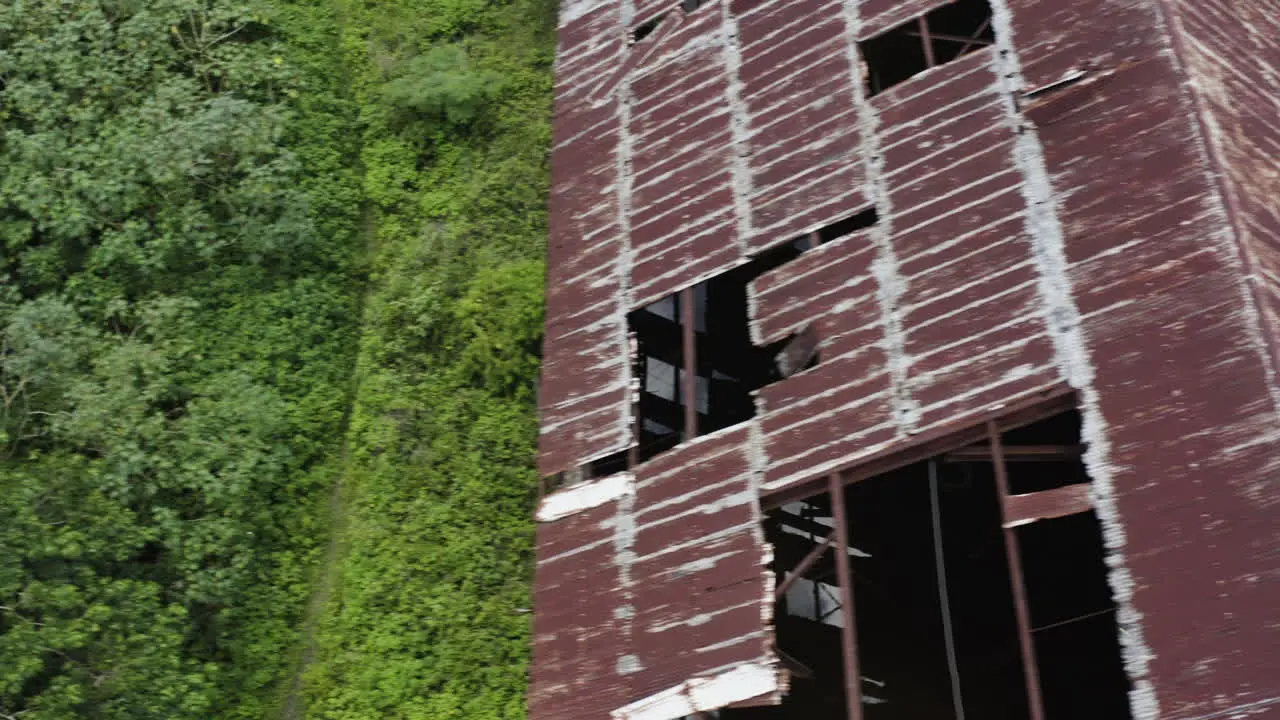 A weather-worn rusty abandoned old factory is being reclaimed by mother nature in the heart of the jungle