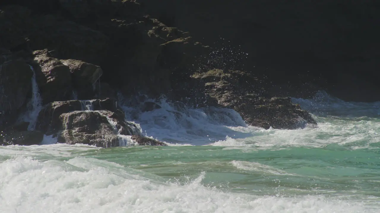 Waves Crashing On Rugged Coastal Cliff With Backwash