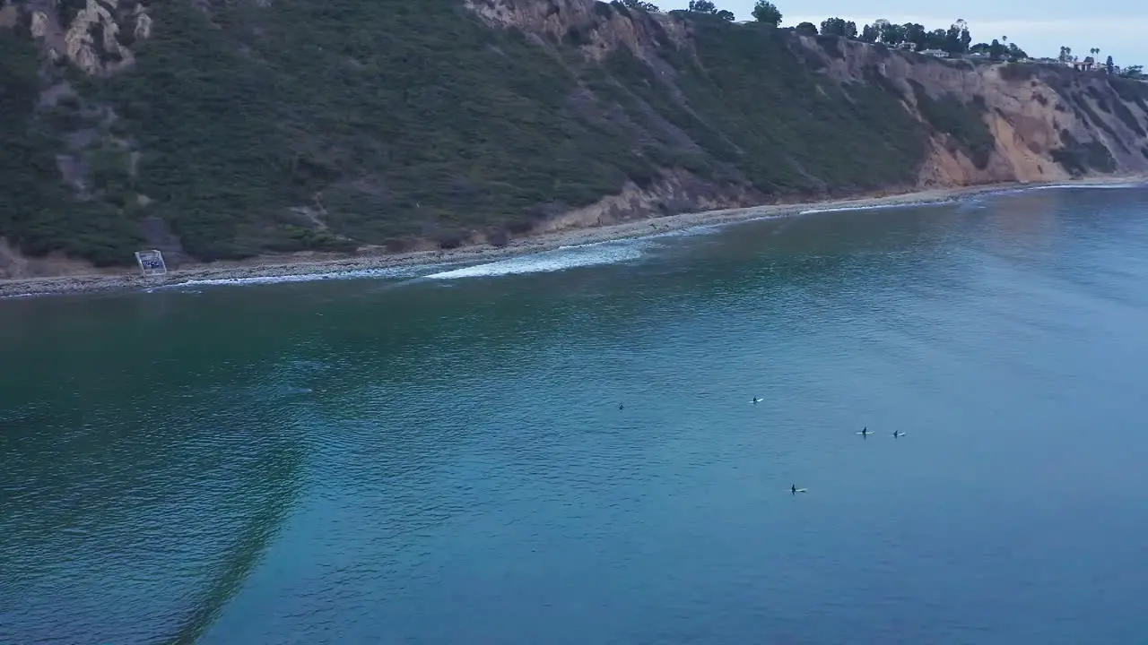 Surfers wait on their longboards to catch a wave a ride it in to shore aerial view near Rancho Palos Verdes