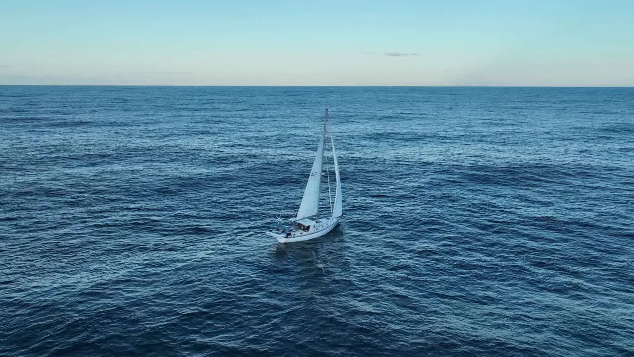 Drone rotational shot of single lone Sailing Yacht in ocean at full sail