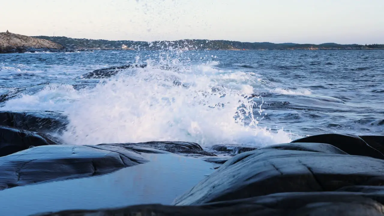 Slow motion shot of waves crashing the coast of the Justoy island on the Skagerrak sea sunny morning in Aust-Agder Norway