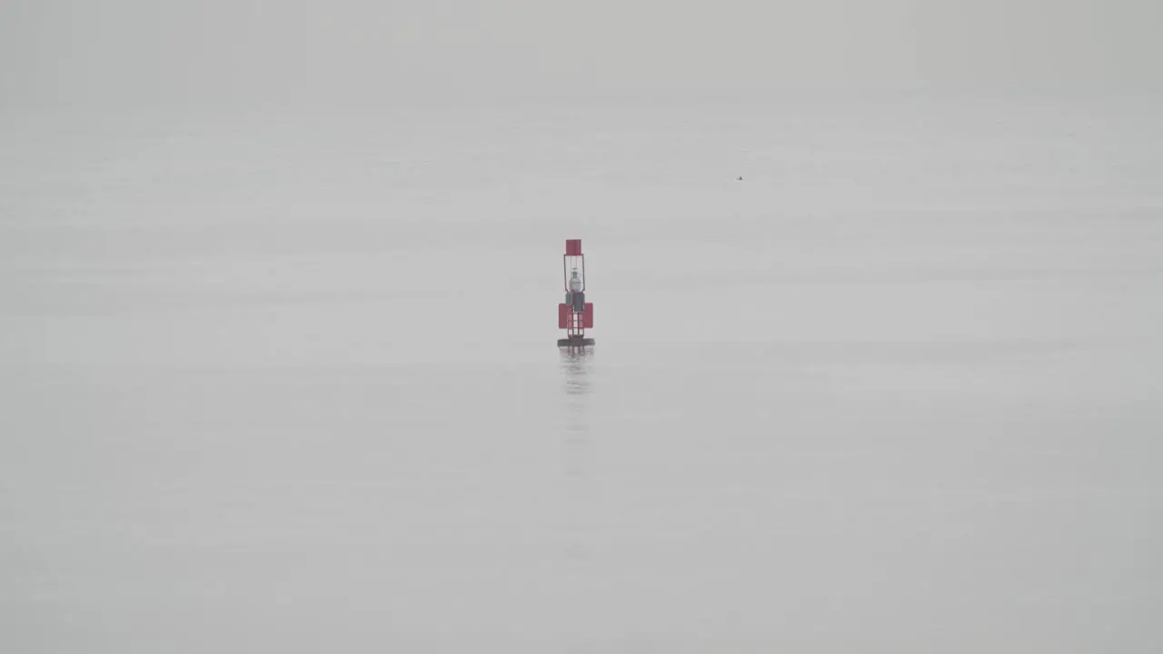 Fishing buoy floating in calm sea in a cloudy day in slow motion 60fps