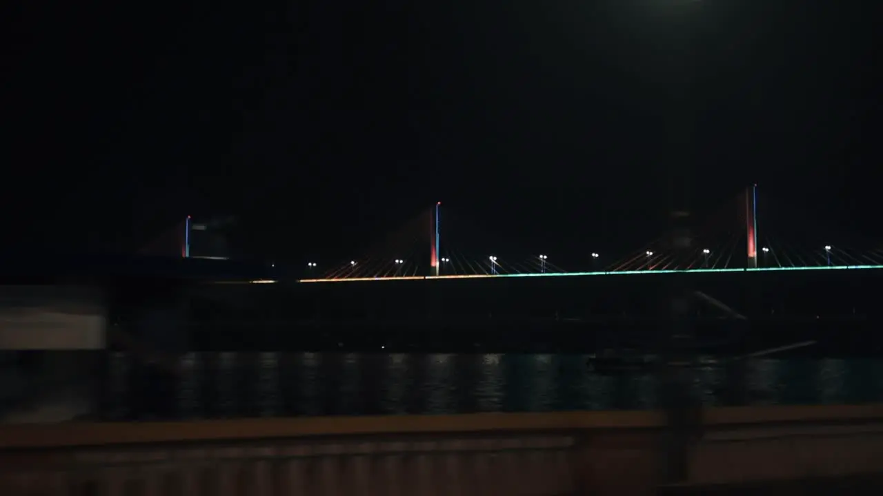 Passing by an illuminated cable-stayed bridge at night