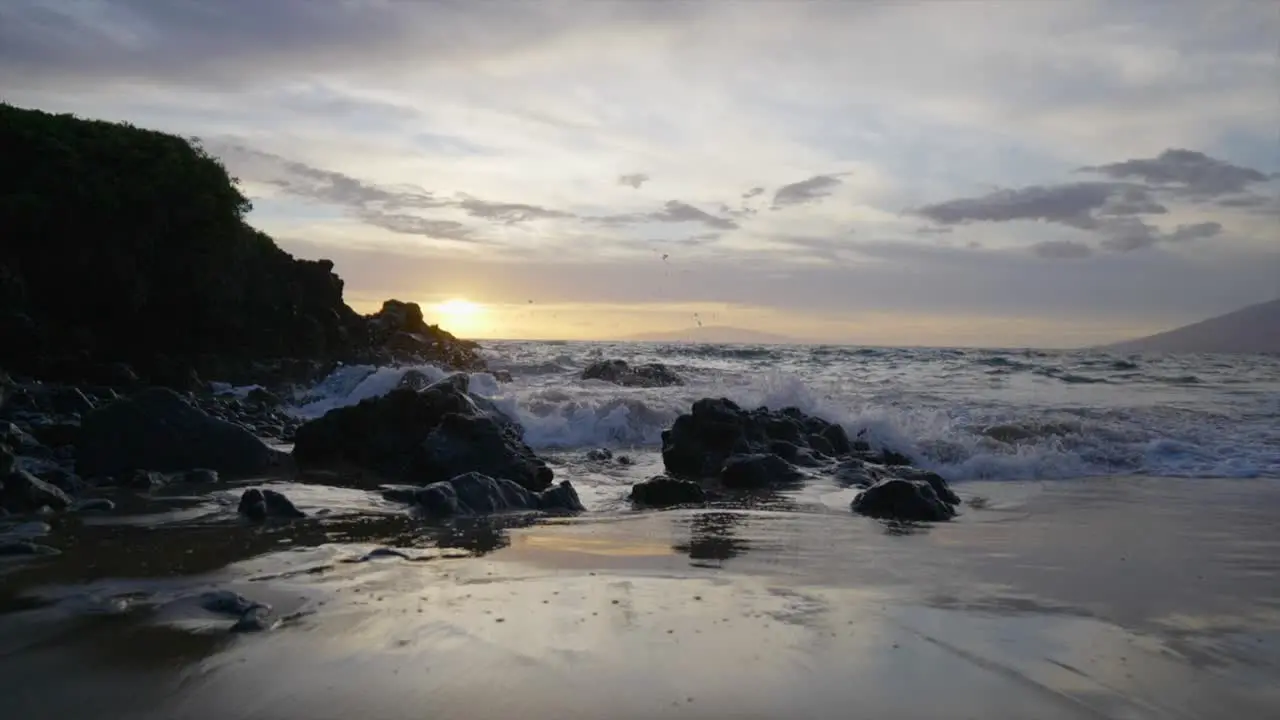 Waves impacting a rocky beach at sunset in Maui Hawaii