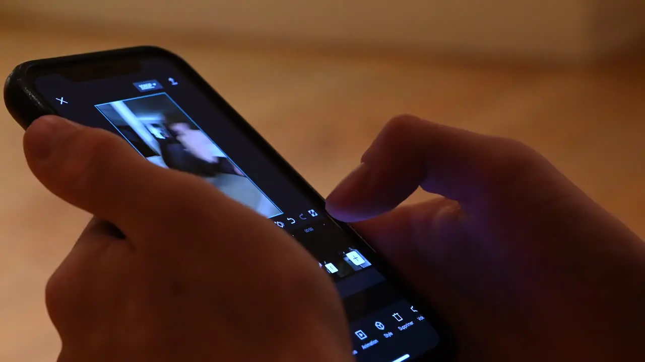 A young is watching a video on his phone social media using