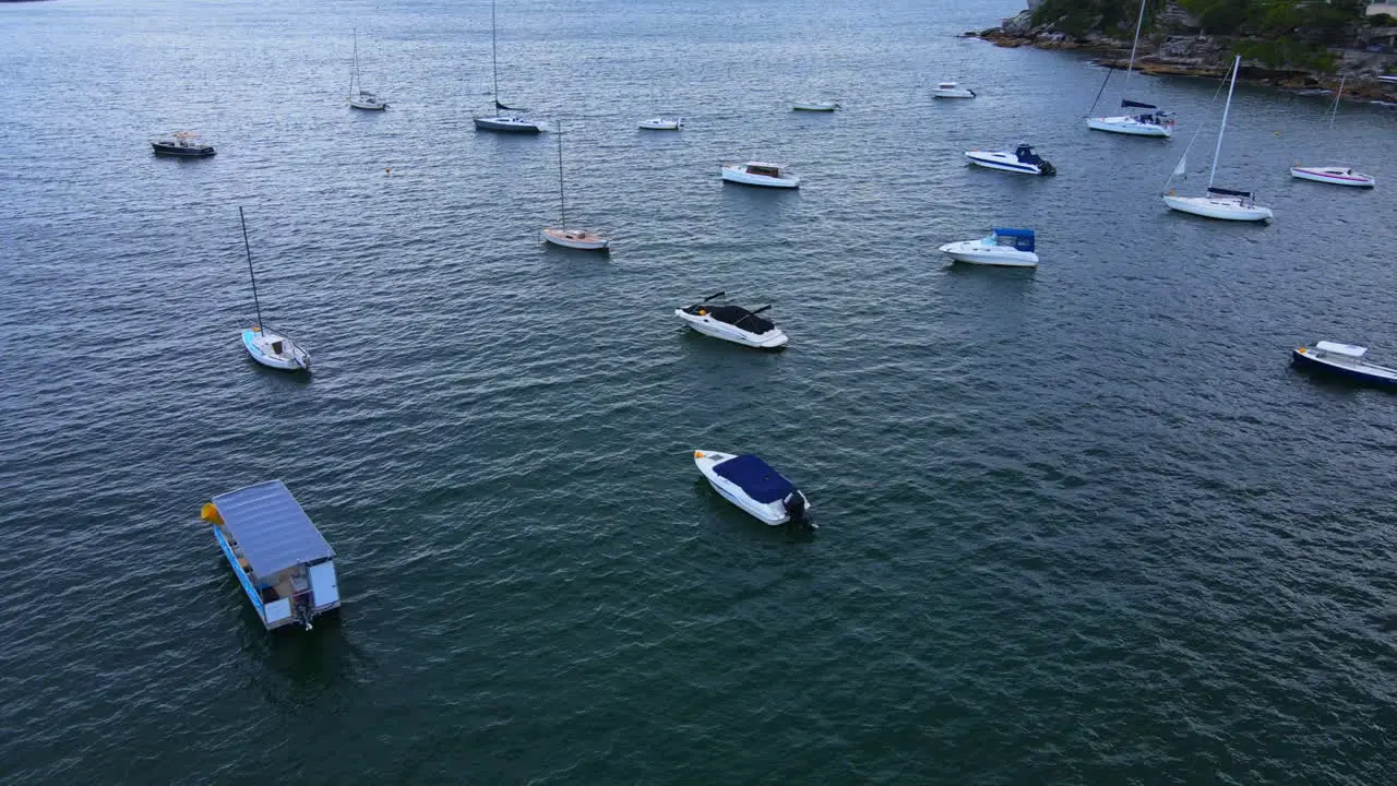 Drone shot over anchored boats panning to houses in Australia