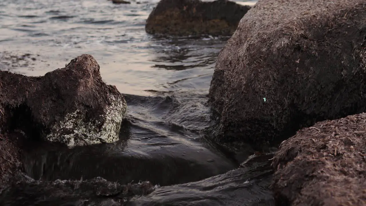 Sea waves movements between huge sea rocks in shore beach in Alghero Sardinia island Italy