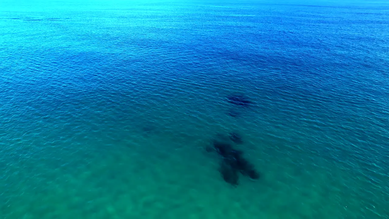 Drone flies above blue azure turquoise Pacific Ocean in Cabo Mexico