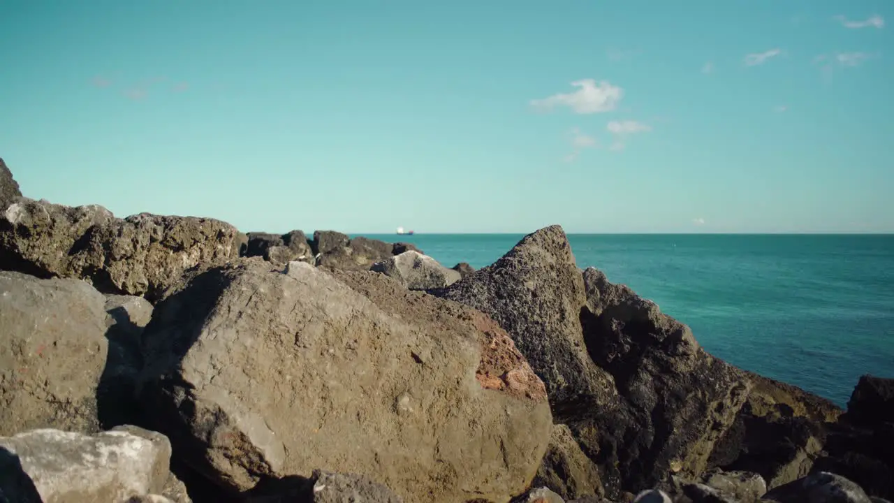 Peaceful ocean view at shore with rock cliff with blue sky at Cascais Portugal 4K traveling shot