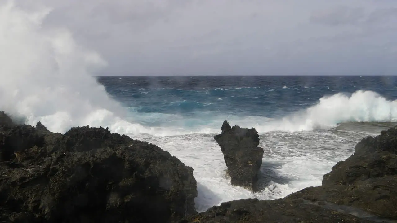 Waves from Pacific ocean crash against rocky shoreline