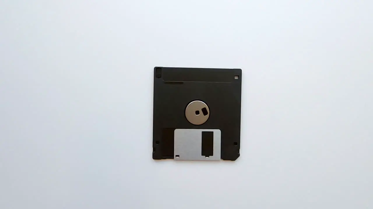 Zooming out from an old vintage floppy disk on a white background