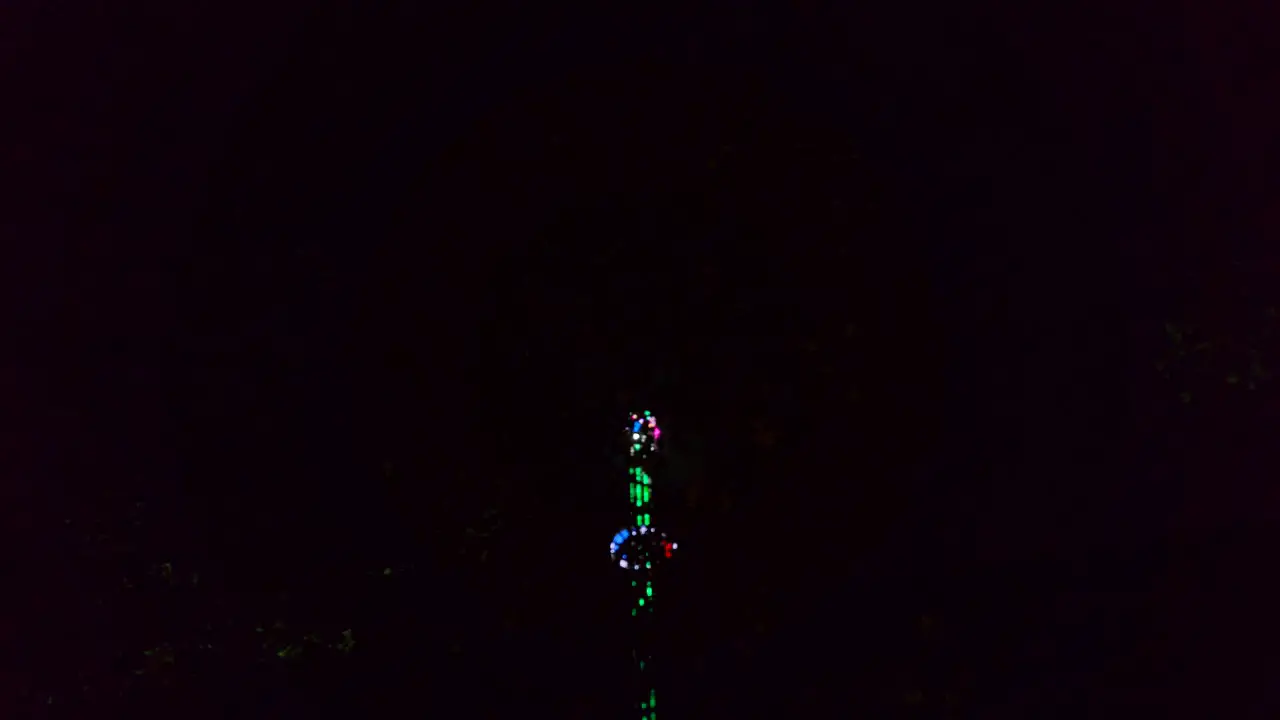 Low angle shot of rotating a chain carousel with a lifting mechanism beautifully lit up in an amusement park in winter wonderland London UK at night time