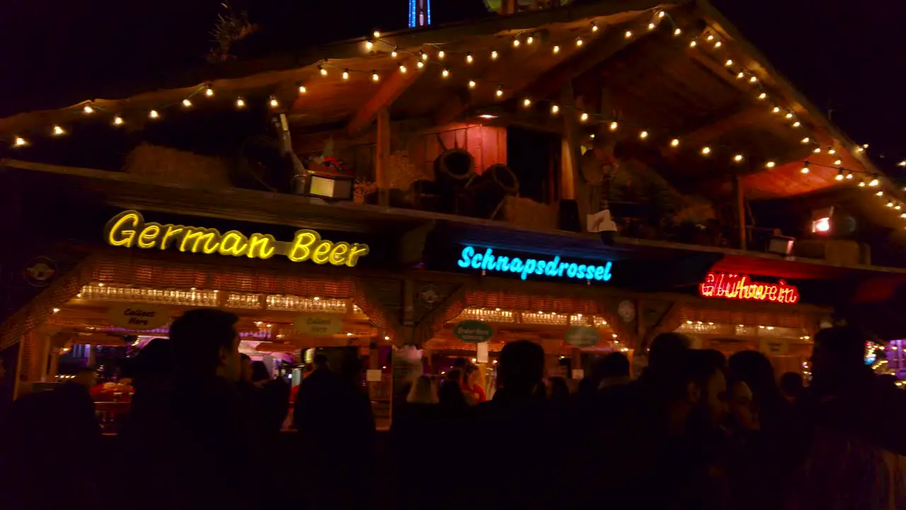 Shot of crowd walking around the street of winter wonderland in London UK at night time with roadside food stalls