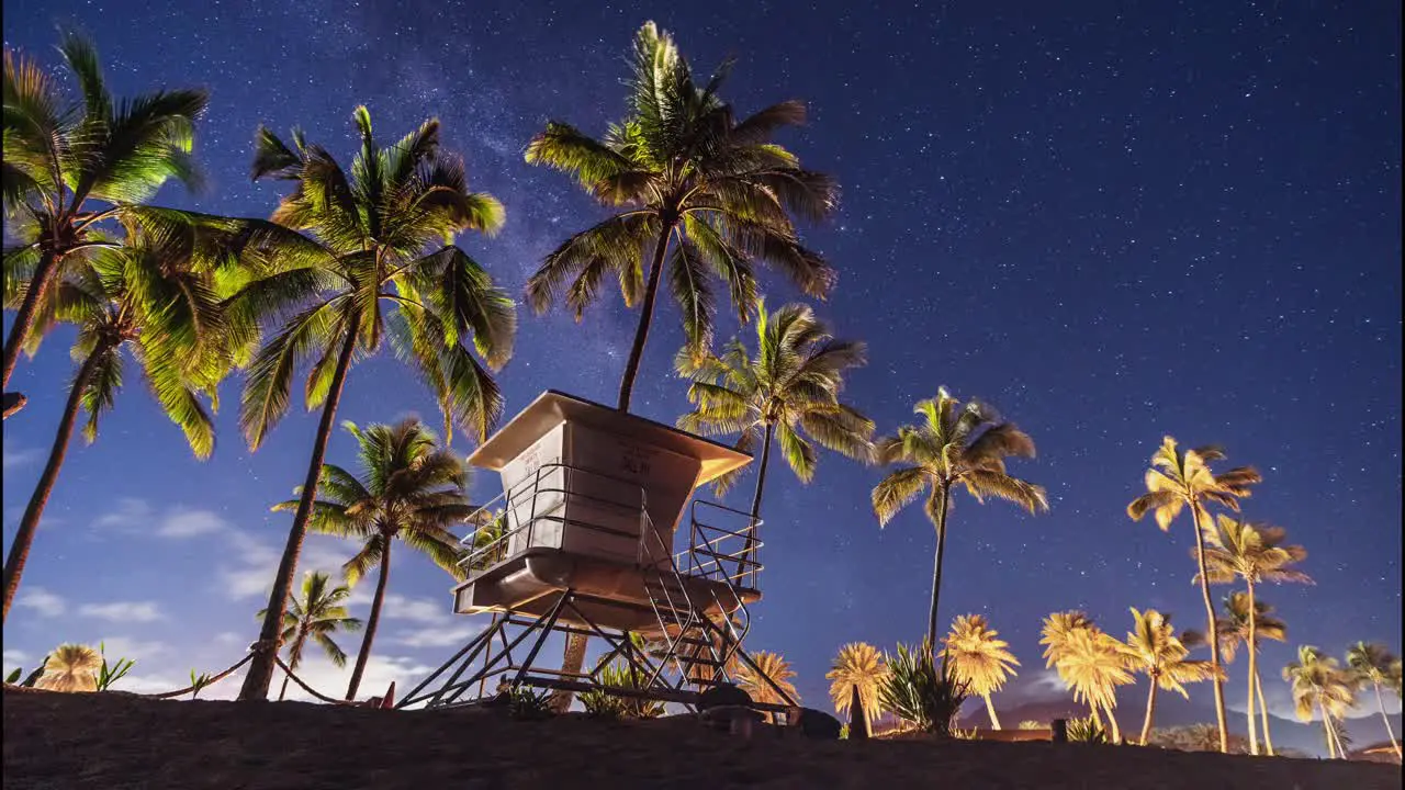 Night Timelaspe of Haleiwa Beach Park with Clouds and Stars Passing Behind the Lifeguard Station Before Dawn Breaks Oahu Hawaii