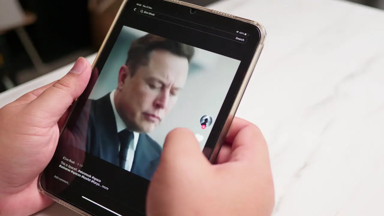 Man using tablet watching TIKTOK application for Elon Musk