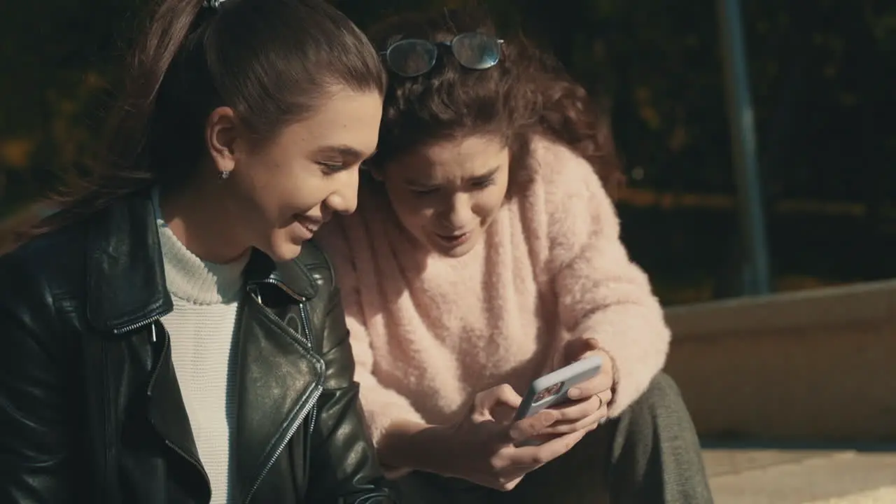 Jóvenes Amigas Usando Un Teléfono Inteligente Al Aire Libre