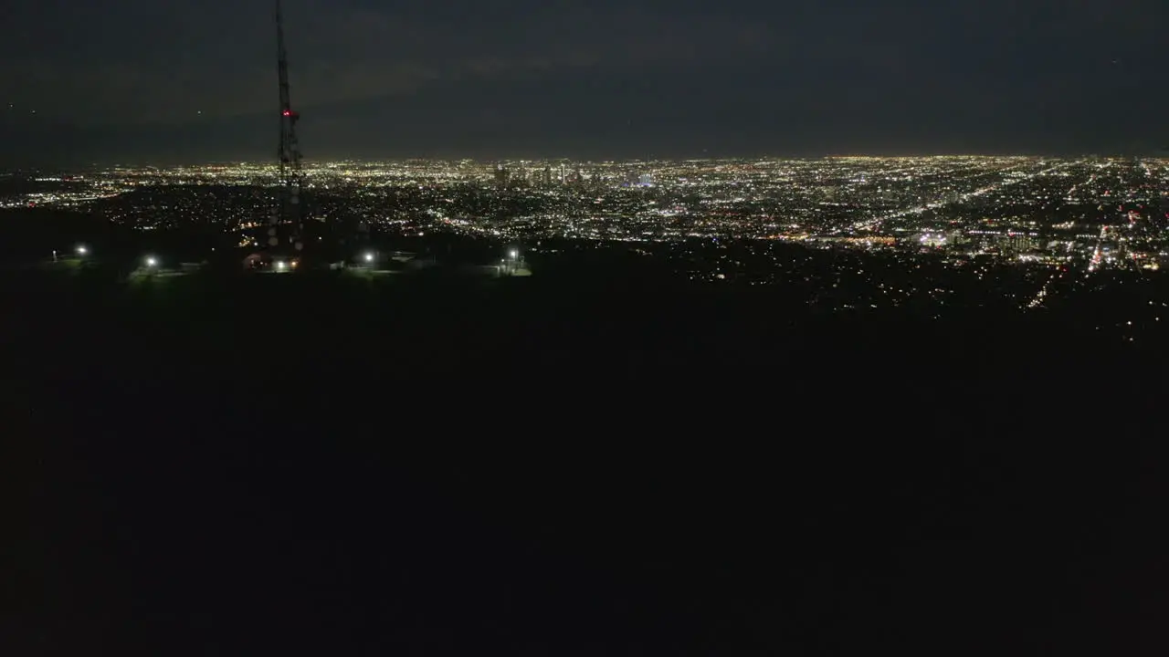 Antena Espectacular Vuelo Sobre El Monte Lee Y El Cartel De Hollywood En La Noche Con Las Luces Del Paisaje Urbano De Los Angeles