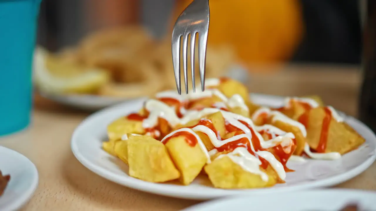 Close up on typical Spanish dish "Patatas Bravas" roasted potatoes with ketchup and mayonnaise on them