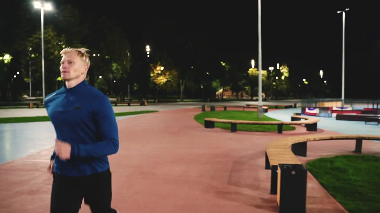 Focused Blond Man Running Towards Camera In The Park At Night 1