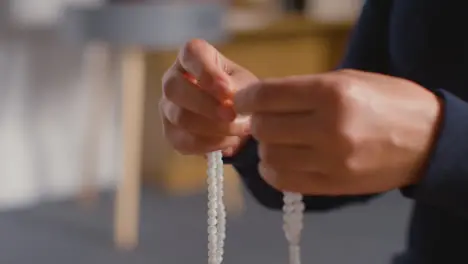 Close Up Of Muslim Woman Wearing Hijab Praying Holding Prayer Beads At Home 1