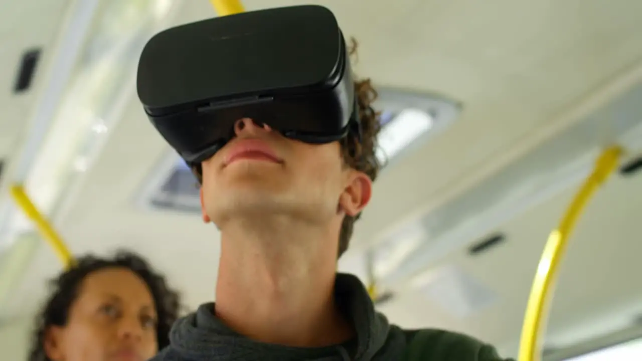 Male commuter using virtual reality headset while travelling in bus 4k