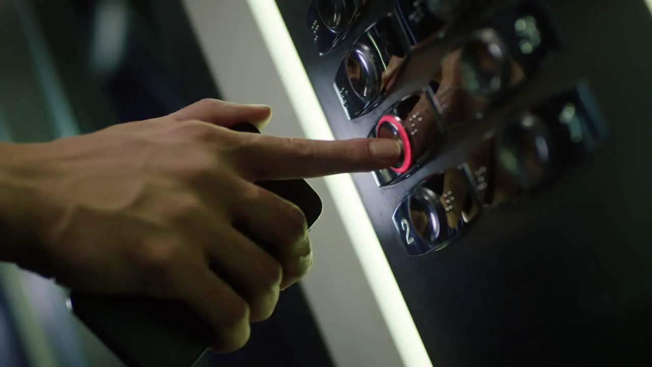 Male hand pushing button with number of floor in elevator Human finger pressing