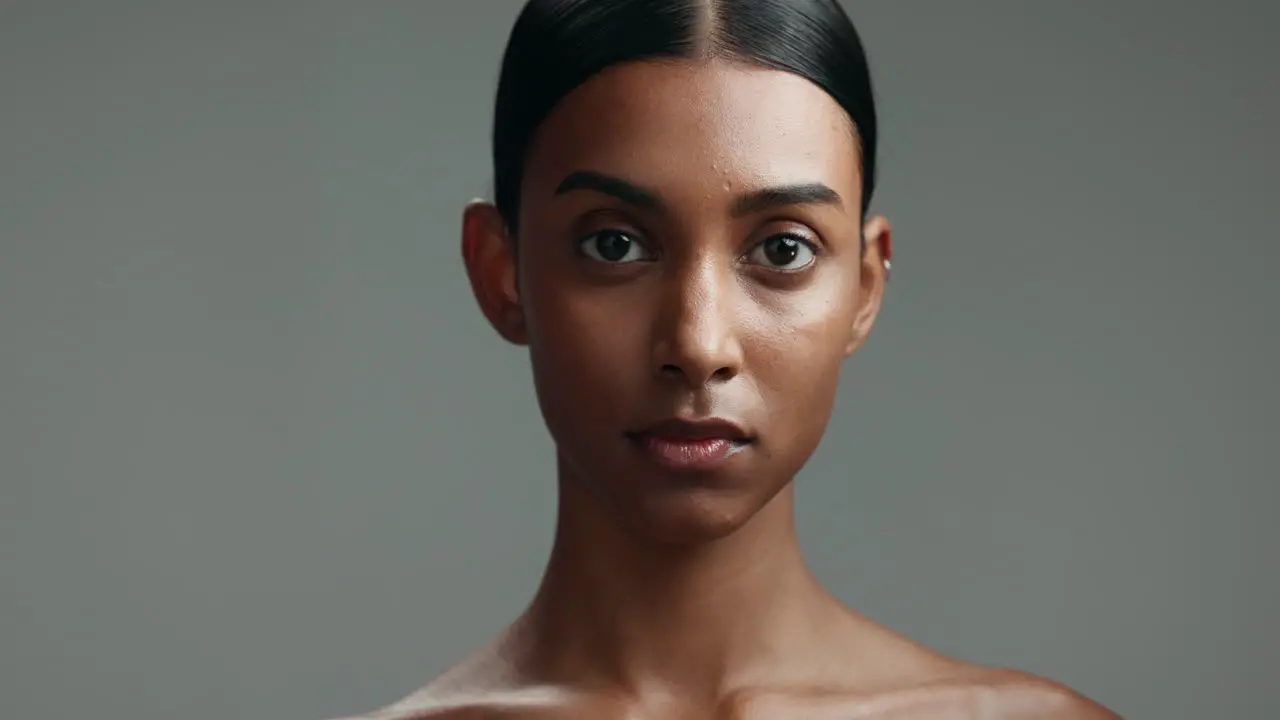 Serious face of Indian woman on gray background