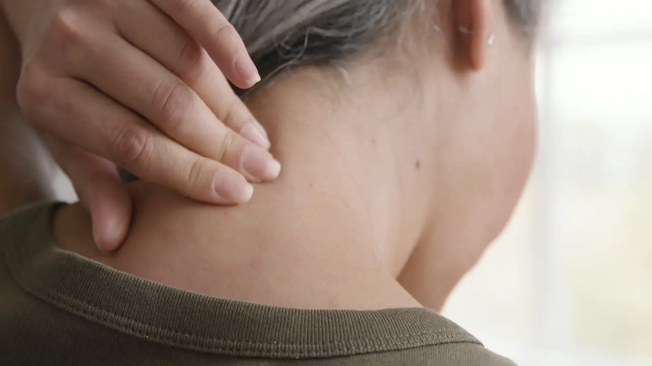 Back View Of A Middle Aged Woman Having Neck Pain