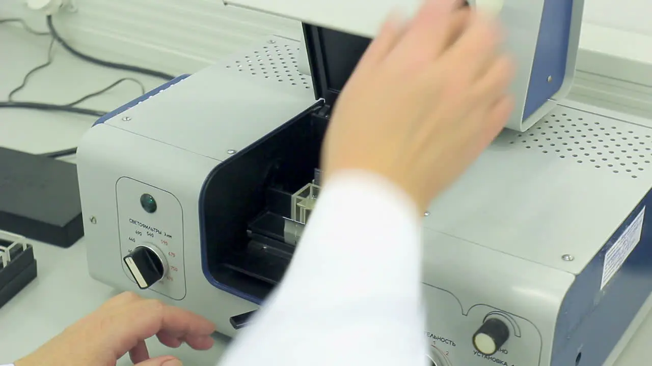 Scientist puts sample into test equipment close cover Modern equipment