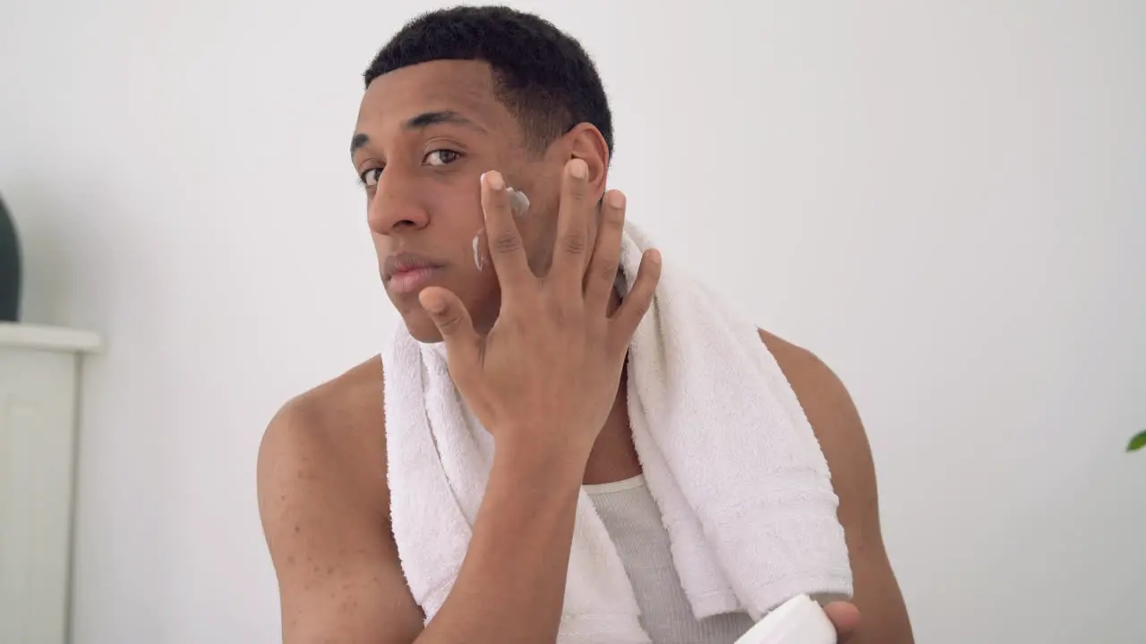 Portrait Of A Black Male Applying Moisturizer