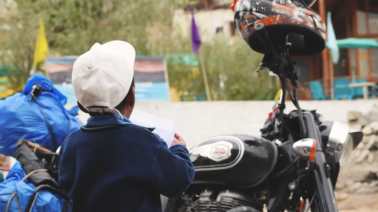 A kid playing with a Tiffen box in the streets of Lamayuru