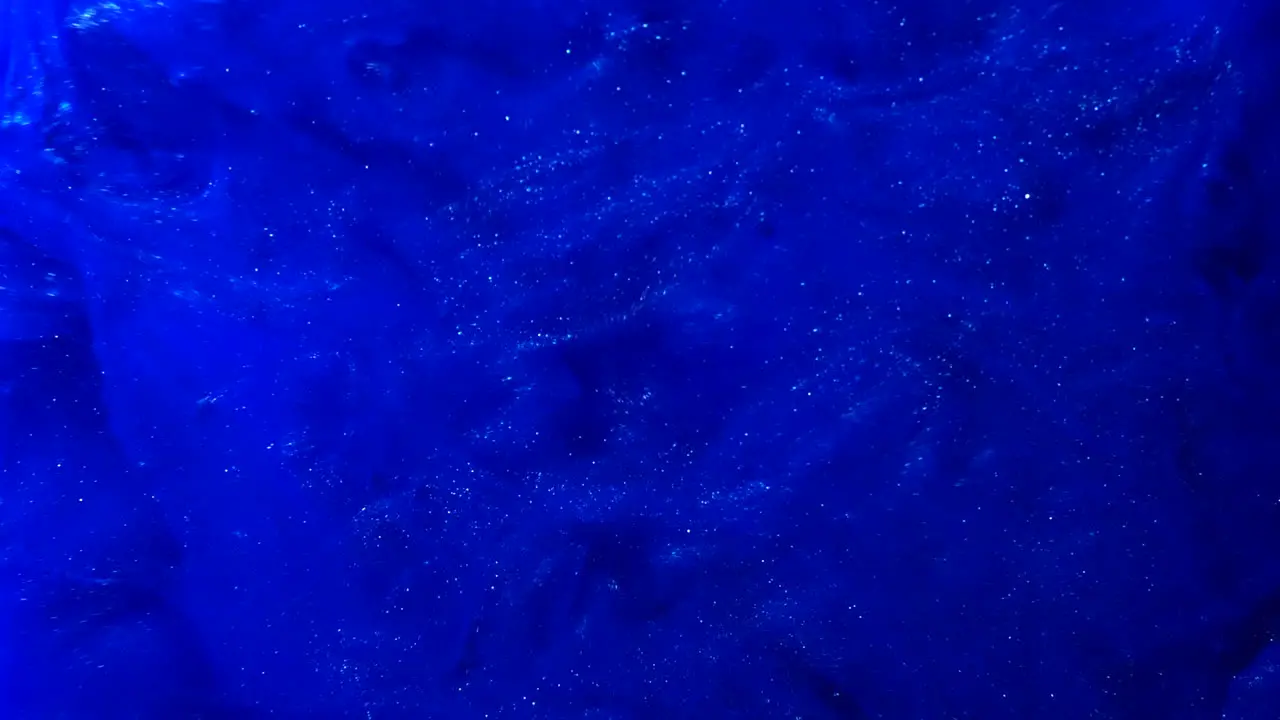 Abstract blue paint splatter background with smokey ink in liquid water SLOW MOTION