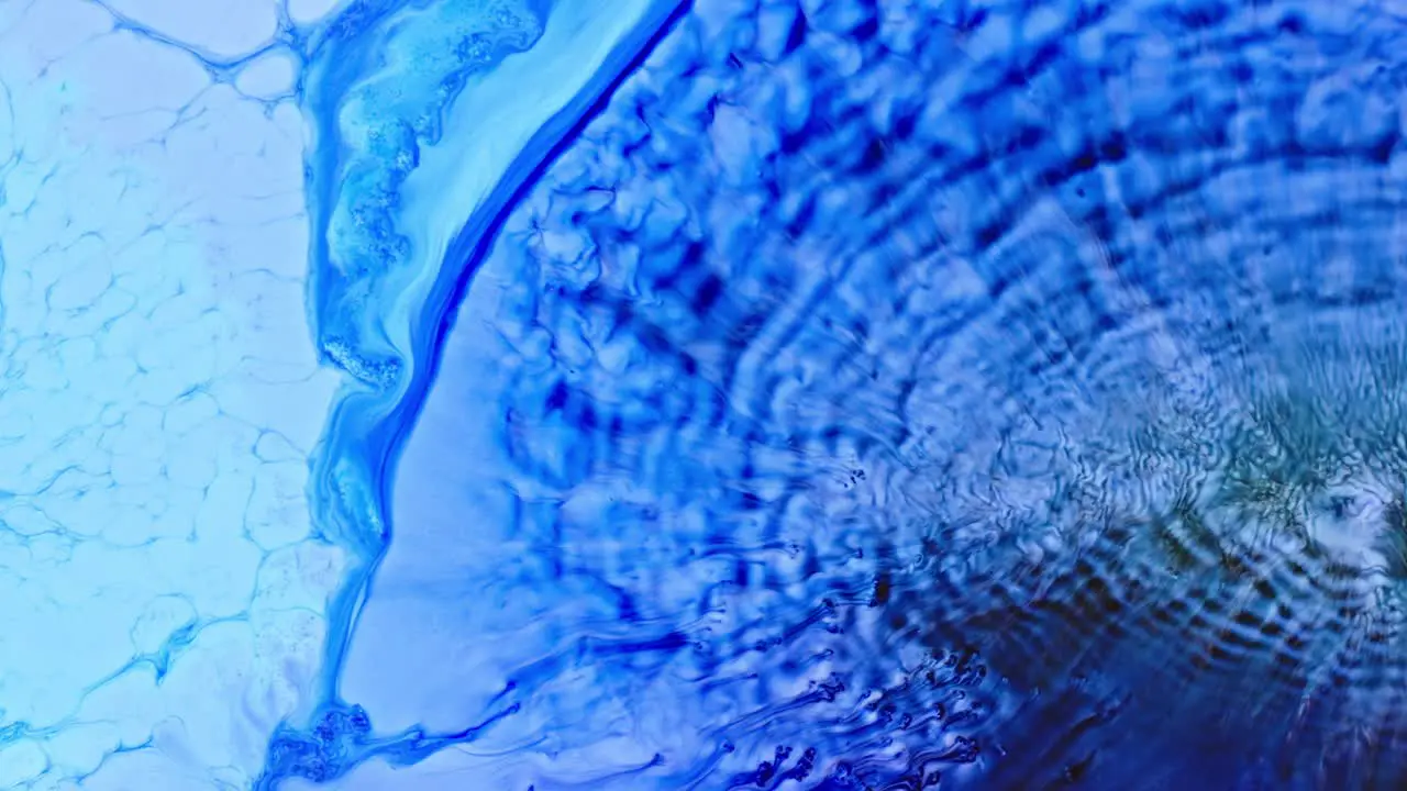 Abstract blue ink diffusing in water creating a dynamic mix of patterns and textures high-detail macro shot