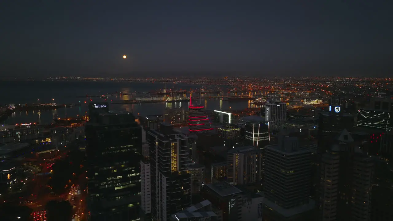 Slide and pan shot of evening harbour on in sea bay Fly above buildings in city centre after sunset Cape Town South Africa