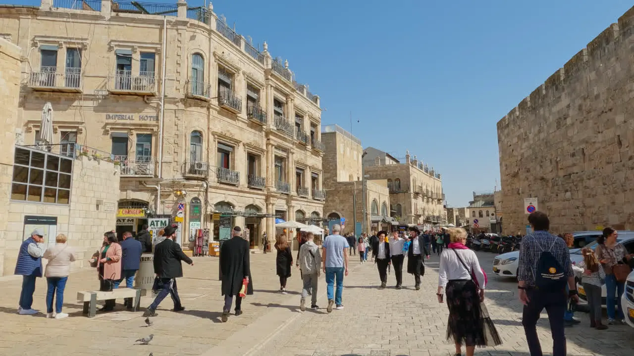 Tourists and religious people explore outside of brick walls in the sacred city