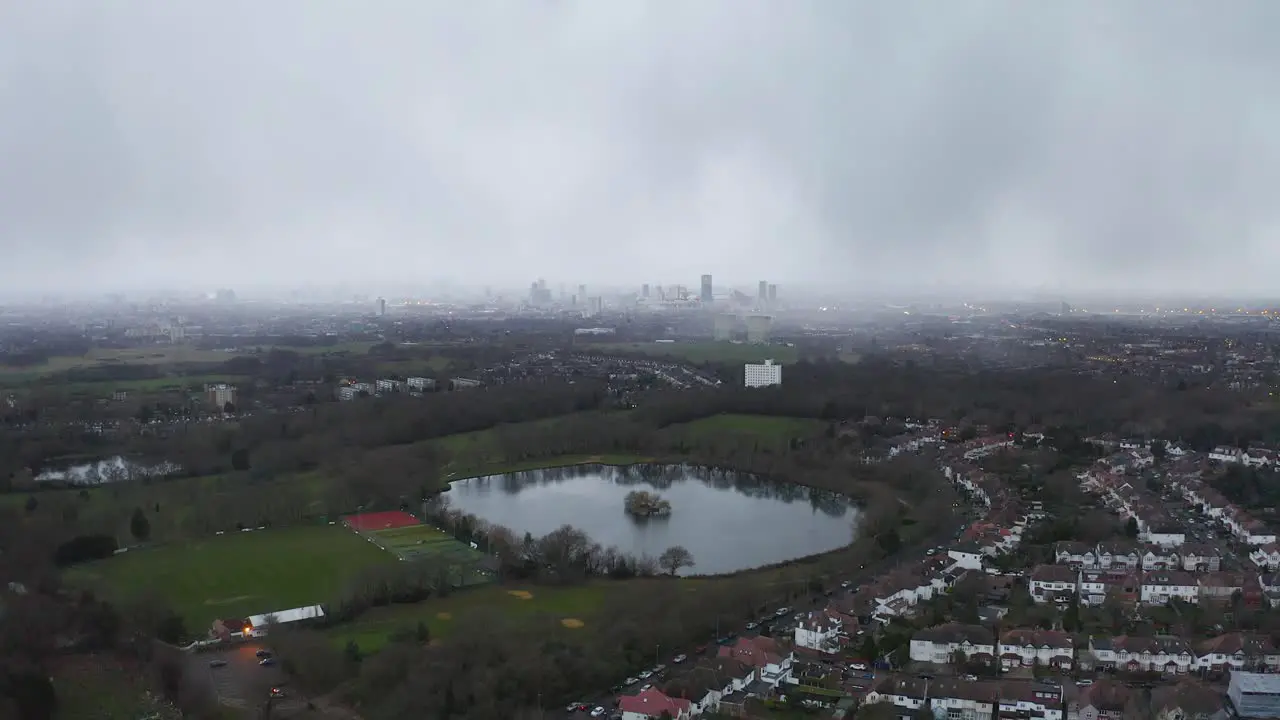 Aerial London approach with lake beneath misty and moody