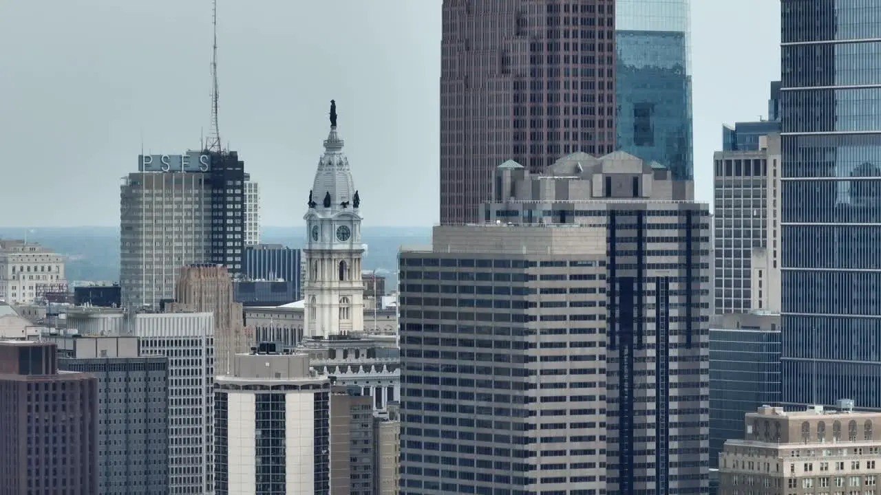 Aerial rotation around city skyscrapers and William Penn statue atop Philadelphia City Hall