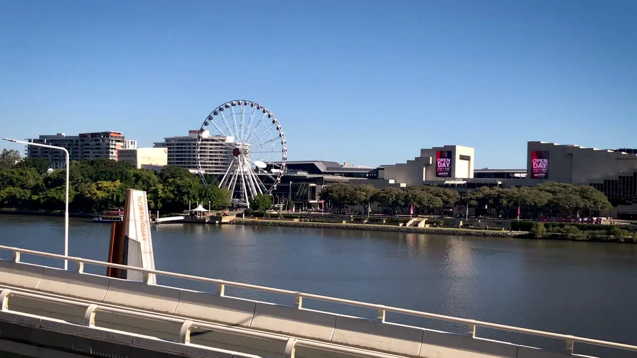 Pan out of The Wheel of Brisbane South Bank with North Quay ferry terminal