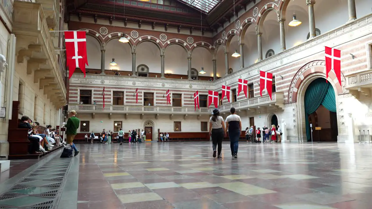 Interior of Copenhagen Town hall with tourist couple walking and kissing