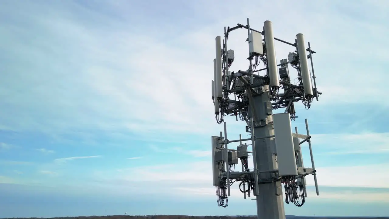 Aerial Shot Rotating Around Cell Phone Tower with Blue Sky in Background