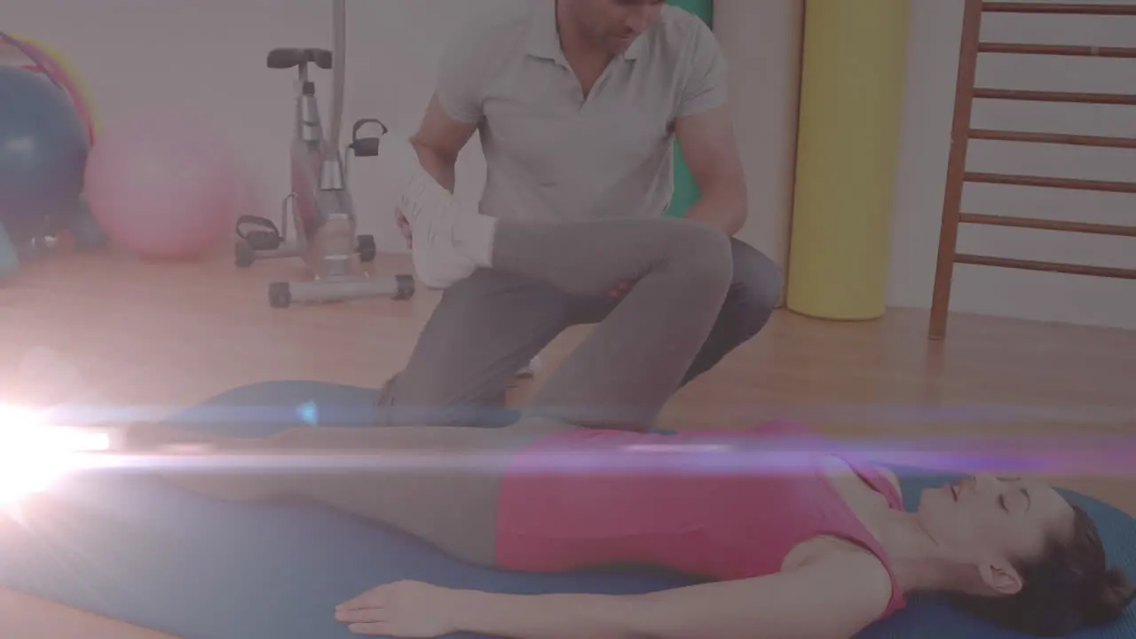 Animation of glowing light over woman exercising with fitness instructor